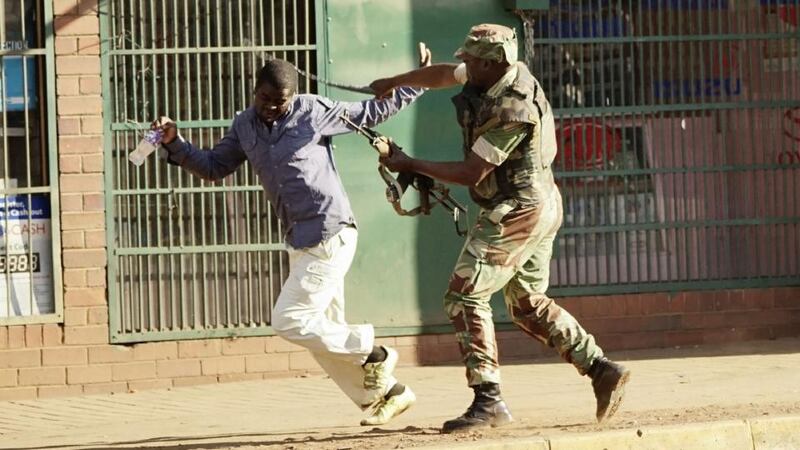 A  soldier beats a man on a street in Harare on Wednesday as protests erupted. Photograph: Zinyange Auntony/AFP/Getty Images