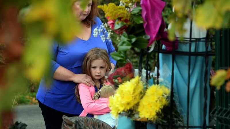 People leave floral tributes the scene of the fire. Photograph: Eric Luke