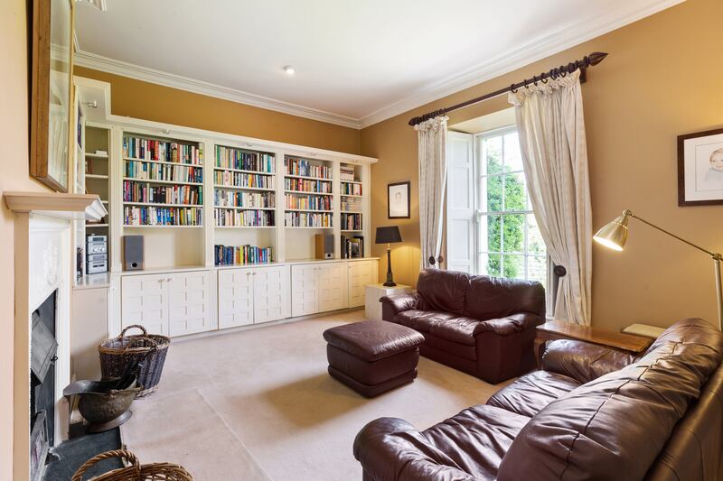 A book-lined family room, again with a feature fireplace and sash windows, lies behind the front rooms.