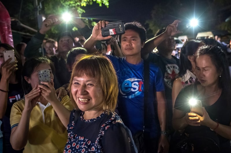 Onlookers watch and cheer as ambulances transport the last rescued schoolboys and  their coach to hospital. Photograph:  Linh Pham/Getty Images