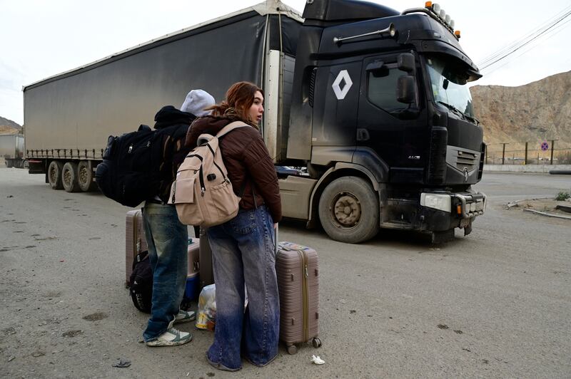Iranian refugees stand with their belongings after crossing the border from Iran to Armenia at a border check point in the southern Armenian town of Meghri, on March 8th, 2026, amid the Middle East war. Photograph: KAREN MINASYAN / AFP via Getty Images