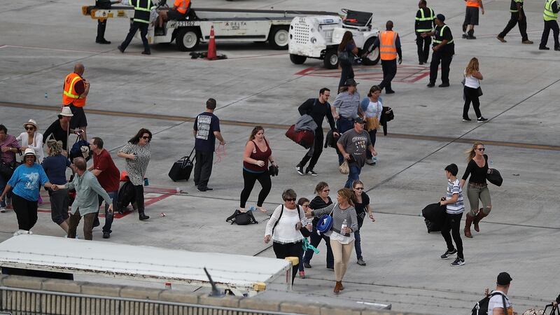 People seek cover on the tarmac of Fort Lauderdale-Hollywood International airport after a shooting took place near the baggage claim. Photograph:  Joe Raedle/Getty Images