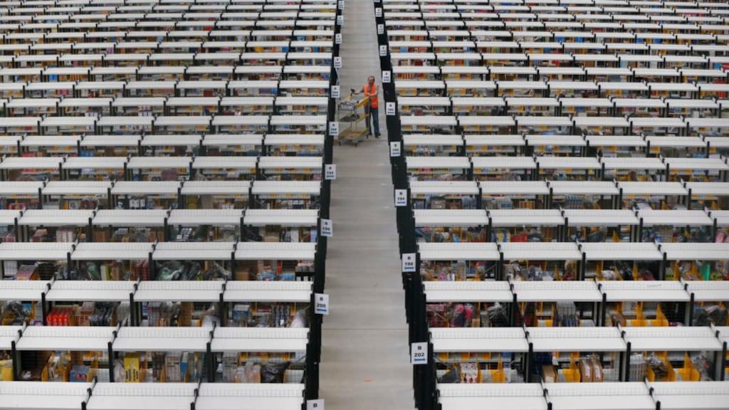 A worker collects orders at Amazon’s fulfilment centre in Rugeley, England. the retailer will be called back to the British parliament to clarify how its activities in the UK justify its low corporate income tax bill. Photograph: Phil Noble/Reuters