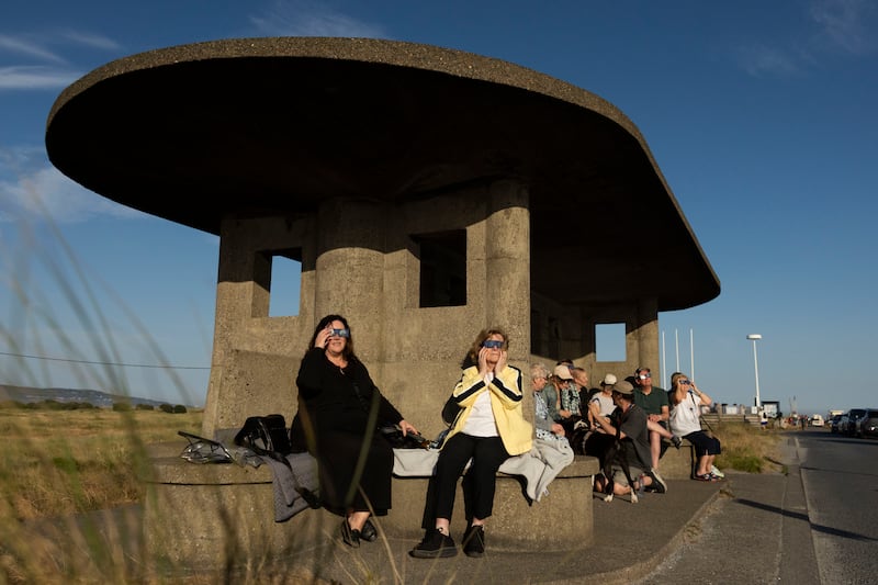 People observe the eclipse on the Bull Wall in Clontarf, Dublin. Photograph: Tom Honan