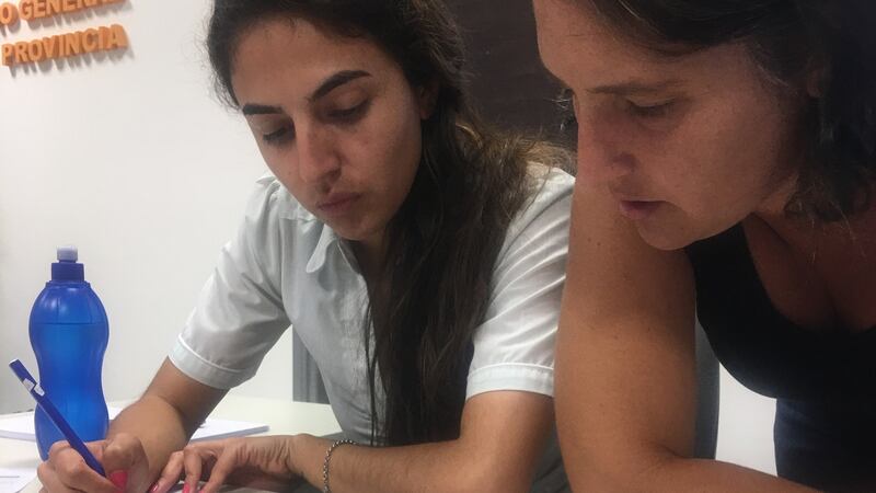 Sabina Bustos and Nadia Bolgan, of the property records office in Laboulaye, Argentina, looking at documents