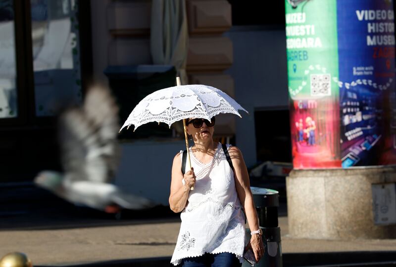 A woman walks with an umbrella during a hot day in downtown Zagreb, Croatia, on Thursday. Photograph: Antonio Bat/EPA