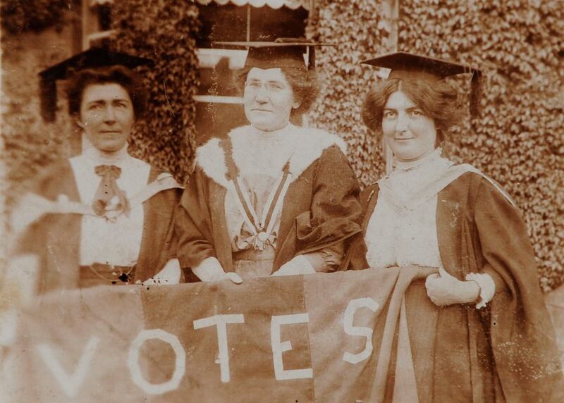 Hanna Sheehy-Skeffington, Kathleen Shannon and Kate Sheedy, in their graduation robes and mortar-boards, carrying a banner saying "Votes" (for women)