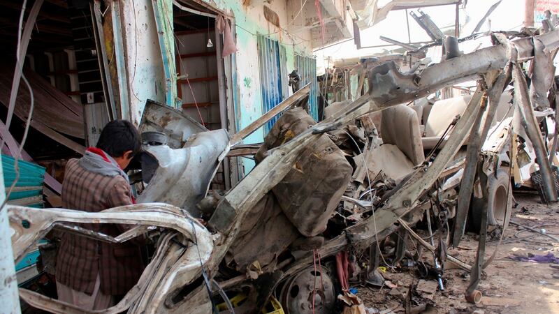 A Yemeni child stands next to the destroyed bus at the site of a Saudi-led coalition air strike, that targeted the Dahyan market the previous day in the Huthi rebels’ stronghold province of Saada last Friday. Photograph: Stringer/AFP/Getty Images