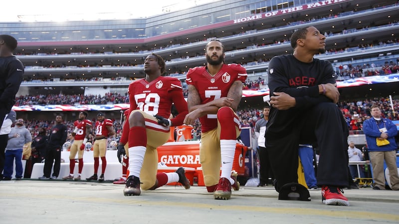 Eli Harold, Colin Kaepernick and Eric Reid  of the San Francisco 49ers kneel on the sideline during the US national anthem in January 2017. Photograph: Michael Zagaris/San Francisco 49ers/Getty Images