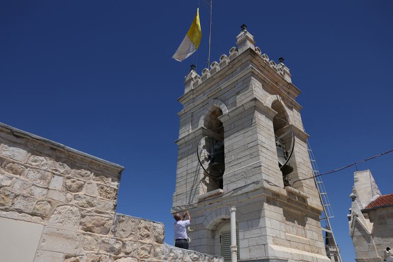 A man lowers the Vatican flag in the Old City of Jerusalem on Monday. Photo: Getty Images