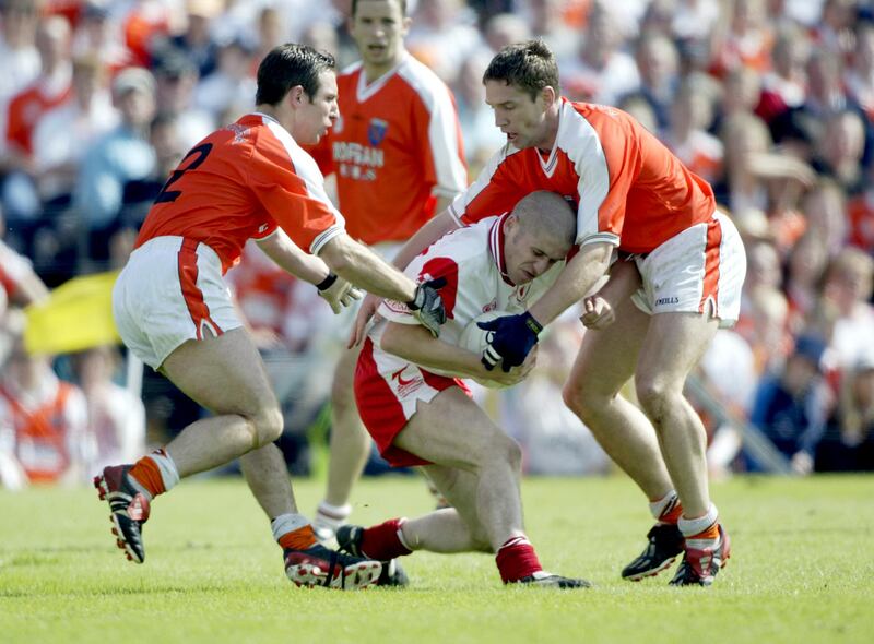 Stephen O'Neill of Tyrone is tackled by Armagh's Enda McNulty and Kieran McGeeney during the 2002 Ulster final replay. Photograph: Patrick Bolger/Inpho