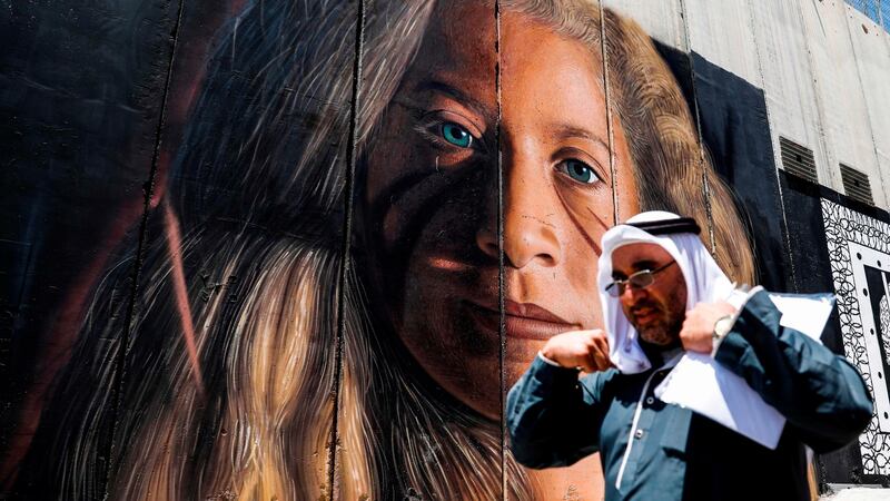A man walks past a mural of Palestinian activist Ahed Tamimi on Sunday, painted on Israel’s controversial separation barrier in the West Bank city of Bethlehem. The teenager was released from prison on Sunday after nearly eight months. Photograph: Ahmad Gharabli/AFP/Getty Images
