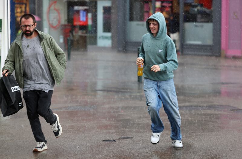 Running for cover from the rain on Grafton Street, Dublin on Tuesday. Photograph: Dara Mac Dónaill 









