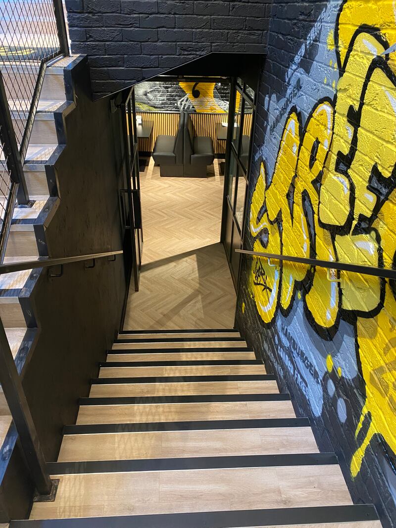 Fat Phill's: The main seating area is reached via a graffiti-covered stairwell