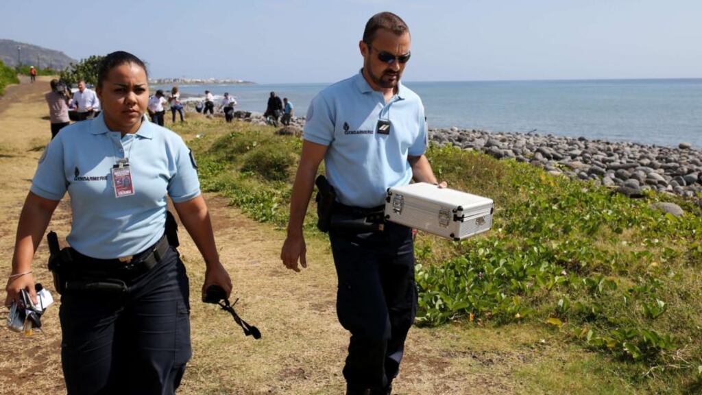 Police officers leave the scene with container holding metallic debris found on a beach in Saint-Denis on the French Reunion Island in the Indian Ocean. Photograph: AFP