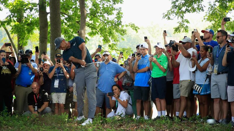 Crowds watch on as Woods plays a shot on the 15th hole. Photo: Andy Lyons/Getty Images