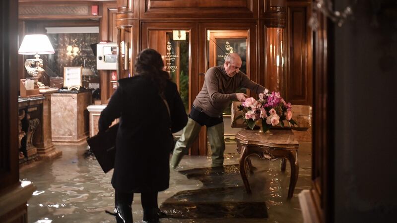 Employees of the Gritti Palace in Venice attempt to protect furniture after an exceptional overnight high tide of 187cm was recorded in the Italian lagoon city. Photograph: Marco Bertorello/AFP via Getty Images.