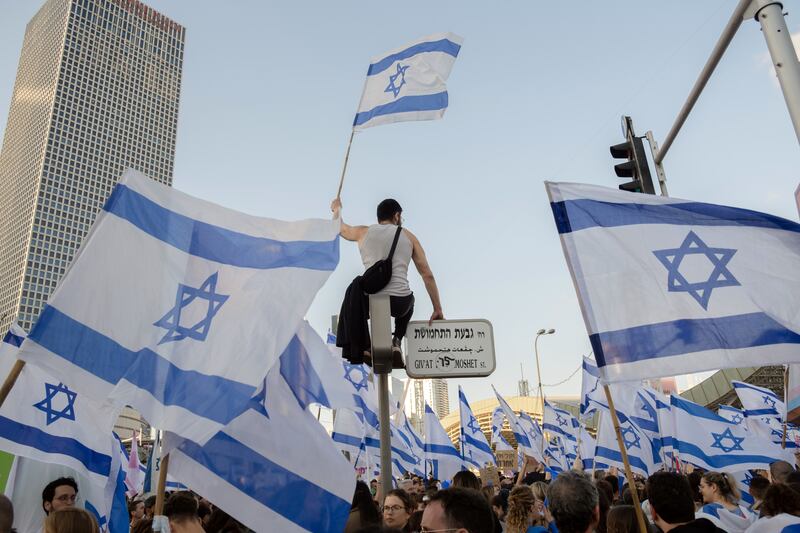 Protesters flag-waving in Tel Aviv. Photograph: Amit Elkayam/The New York Times
                      