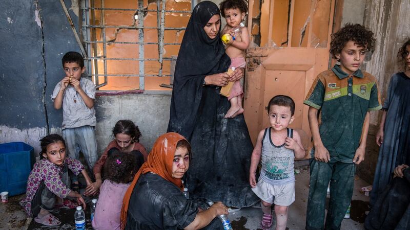 A group of women and children, some accused of being families of Islamic State members, wait for transport to a camp after fleeing an area still under militant control, in the Old City of Mosul, Iraq, on July 12th. Photograph: Ivor Prickett/The New York Times