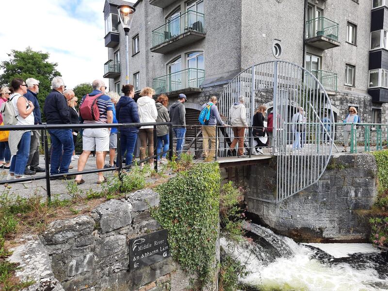 Participants traverse a bridge on a guided walk along the canals of Galway City to observe the remains of mill wheel installations