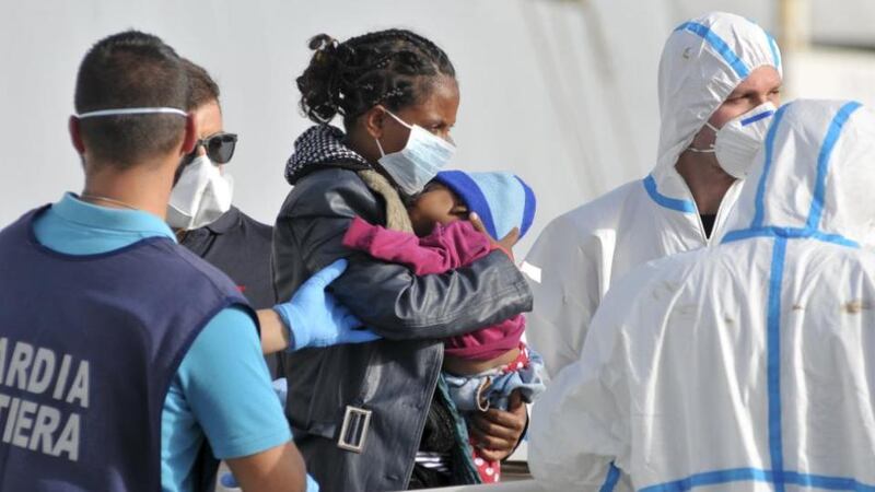 A woman is helped to disembark from the Italian navy ship Borsini in Sicily. Italy has said that 5,800 migrants have been rescued from boats off the coast of Libya and 10 bodies recovered in less than 48 hours. Photograph: Guglielmo Mangiapane/Reuters