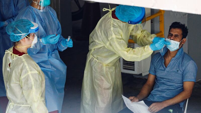 A migrant worker undergoes a nose swab test as medical workers look on at a dormitory amid the coronavirus disease  outbreak in Singapore on Monday. Photograph: Edgar Su/Reuters