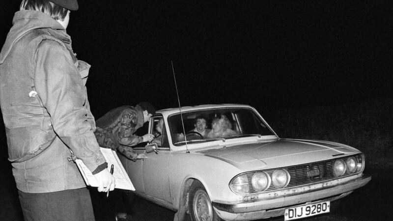 An unarmed female soldier from the 3rd (County Down) Battalion, UDR, running a vehicle checkpoint in Co Down in March 1976 during a night patrol. Photograph:  Alex Bowie/Getty Images