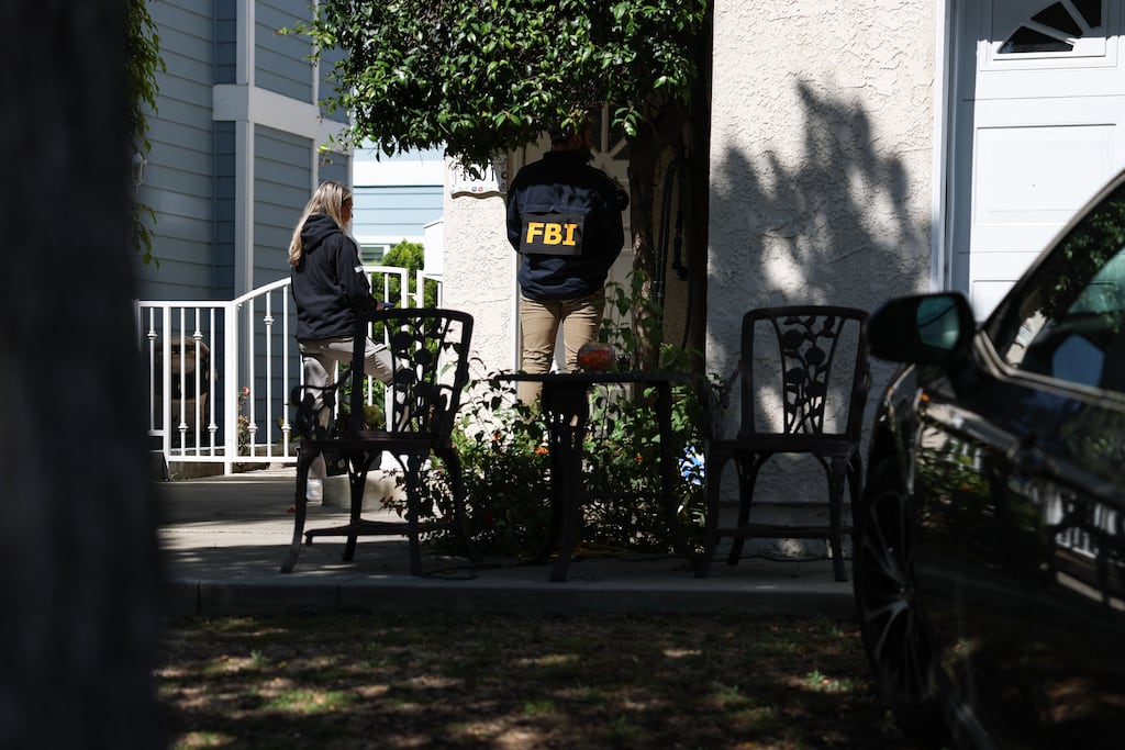 Members of the FBI knock on doors of neighbours of a home in Torrance, California, associated with suspect Cole Tomas Allen. Photograph: Patrick T Fallon/AFP via Getty Images