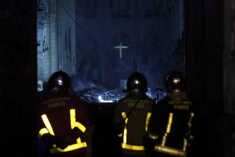 Firemen enter the cathedral as flames  burn the roof.  Photograph: Yoan Valat/EPA