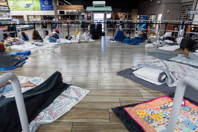 Tourists settle for the night as they wait for a flight to leave the island of Maui at Kahului Airport, Hawaii, in the wake of the destruction caused by wildfires. Photograph: Etienne Laurent/EPA-EFE