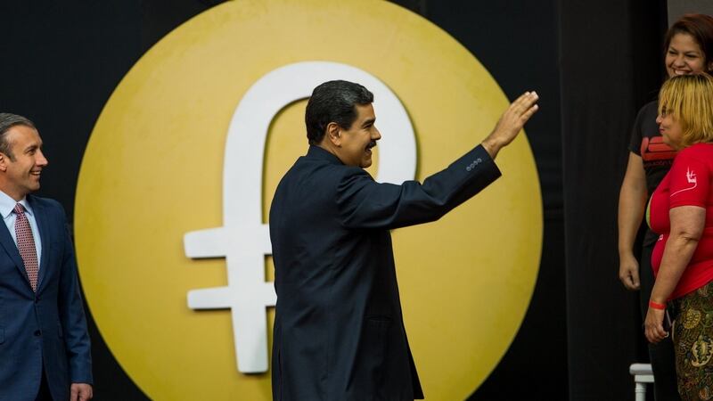 Venezuelan president Nicolas Maduro waves to the audience  during a press conference regarding  the new Venezuelan “petro” cryptocurrency, with the currency’s logo in the background, in Caracas, Venezuela. Photograph: Cristian Hernandez/EPA