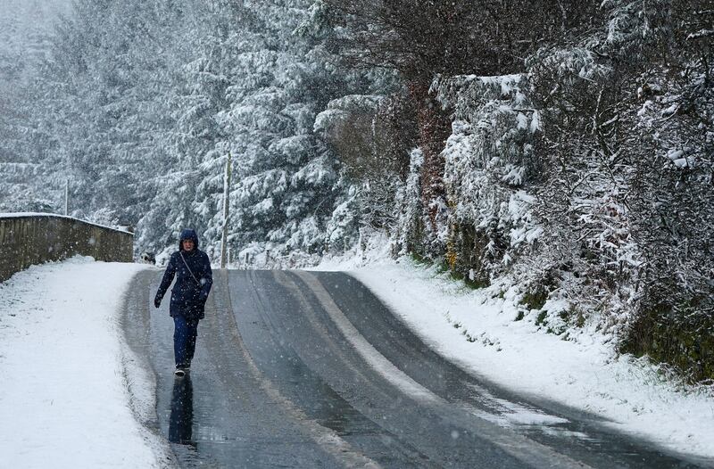 A woman walks a road in Slievethoul, Co. Dublin, following heavy snow fall. Photograph: Brian Lawless/PA