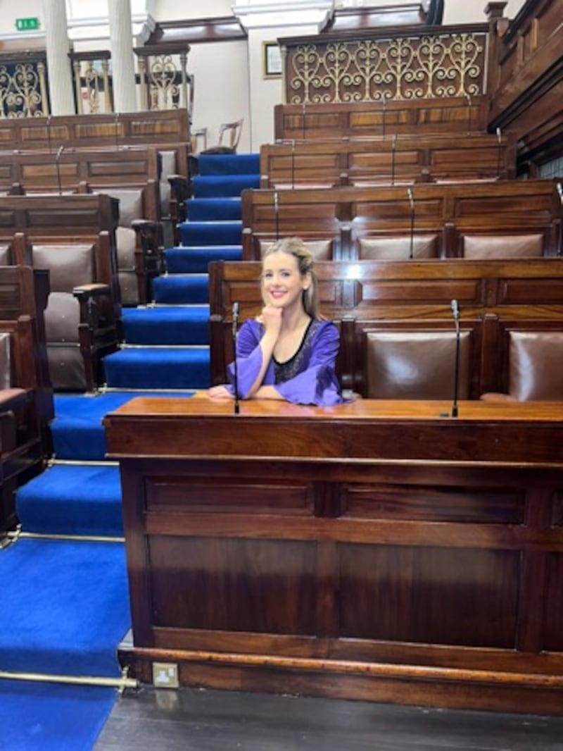 Caelainn McGrath sitting in her father’s seat in the Dáil chamber after she danced in Leinster House during Culture Night