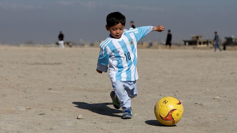 Murtaza Ahmadi (5) wears a shirt signed by Barcelona star Lionel Messi as he plays football at the open area in Kabul in February this year.  Photograph: Reuters