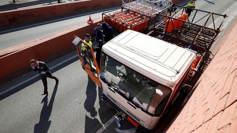 Police work at the scene of a gas cylinder delivery truck with bullet holes in its windscreen. Photograph: Albert Gea/Reuters