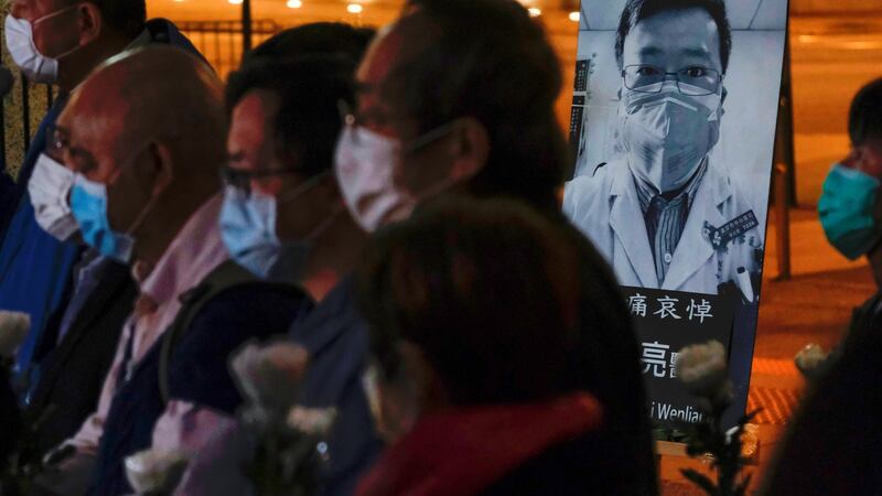 People  attend a vigil for late Dr Li Wenliang in Wuhan. Photograph: Tyrone Siu/Reuters