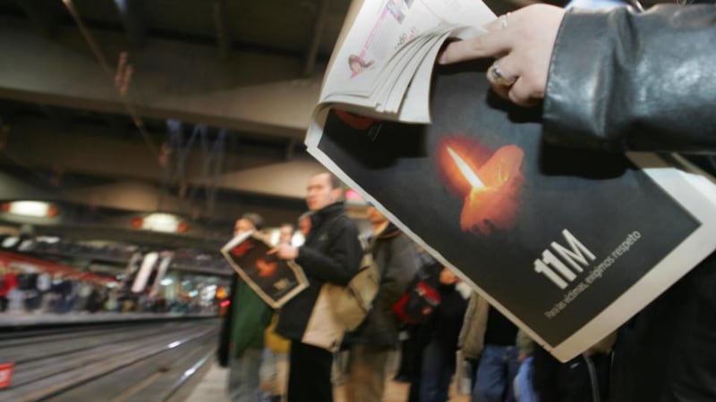 Passengers waiting for a train on the platform 2 of Atocha railway station read newspapers on March 11th, 2005, with front pages commemorating the victims of the 2004 Madrid train bombing. Photograph: Christophe Simon/AFP/Getty Images
