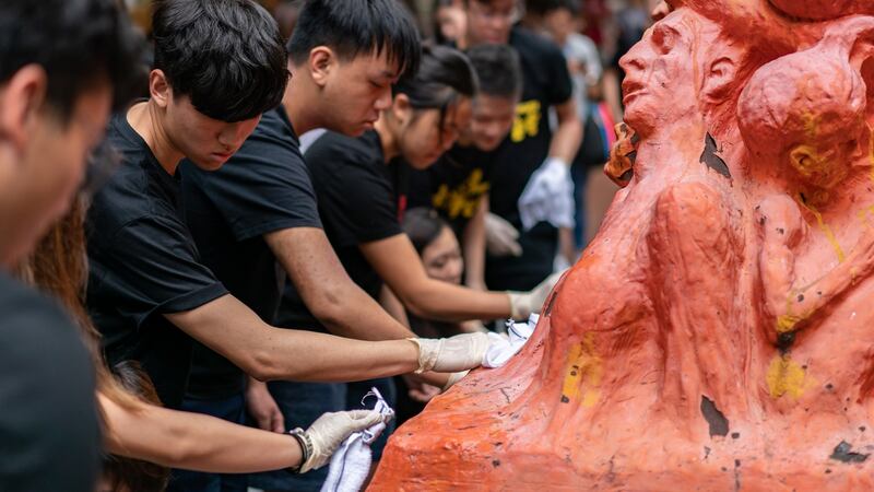 Students clean the “Pillar of Shame” statue, an art piece dedicated to the victims of the 1989 Beijing Tiananmen Square massacre, at the University of Hong Kong on Tuesday. Photograph:  Anthony Kwan/Getty Images