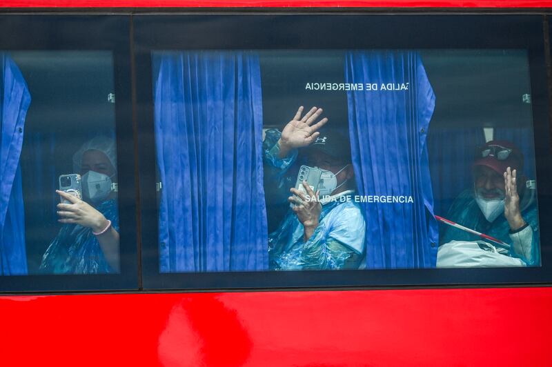 Passengers evacuated from the MV Hondius wave from a military bus after being transferred by boat to the port of Granadilla de Abona on Tenerife on Sunday. Photograph: Jorge Guerrero/AFP via Getty