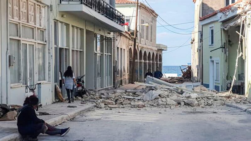 People walk past a destroyed house after an earthquake in the island of Samos on October 30th. Photograph:  STR/Eurokinissi/AFP via Getty
