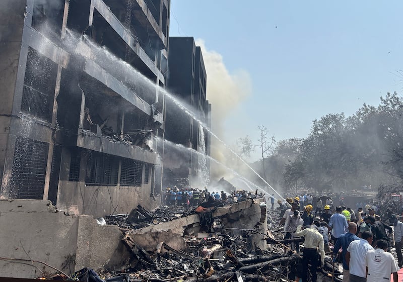 Firefighters work at the site of the crash. Photograph: Siddharaj Solanki/EPA