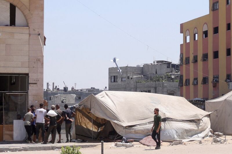 TOPSHOT - Palestinians watch as a rocket fired by an Israeli war plane targets a building in Jabalia in the northern Gaza Strip on August 20, 2025. Israel's defence minister approved a plan on August 20, for the conquest of Gaza City and authorised the call-up of around 60,000 reservists, piling pressure on Hamas as mediators push for a ceasefire. (Photo by BASHAR TALEB / AFP) (Photo by BASHAR TALEB/AFP via Getty Images)          
