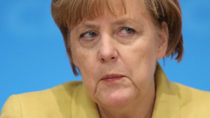 Sister act: Angela Merkel’s buttoned-down sobriety  achieves the same end in her world as Dolly Parton’s sequinned dazzle  does in hers: it triggers emotional appeal. Photograph: Sean Gallup/Getty