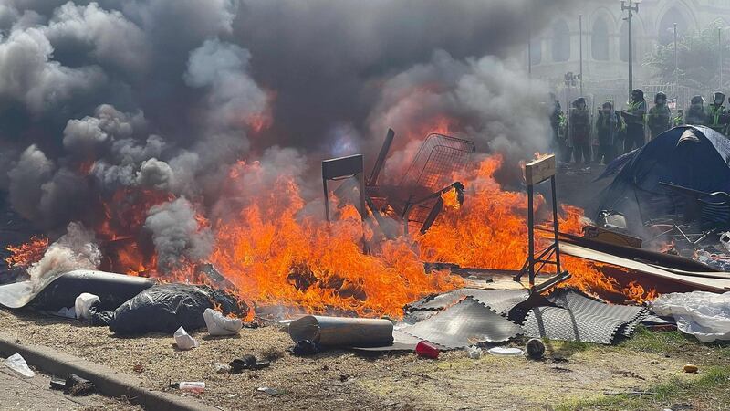 A fire rages as police move in to clear protesters from parliament grounds in Wellington. Photograph: Marty Melville/AFP via Getty Images