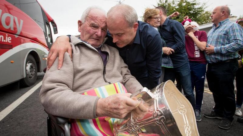 Micheál Donoghue shares an emotional moment with his father as he presents him with the Liam MacCarthy cup. Photo: Morgan Treacy/Inpho