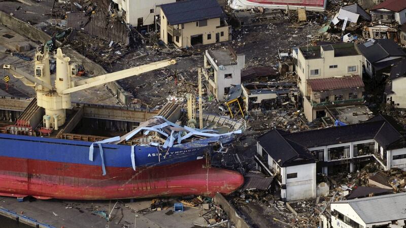 An under-construction boat sits on land next to damaged homes in the city of Kamaishi after  a massive 8.9 magnitude quake and tsunami hit the region on March 11th,  2011. Photograph:  Yomiuri Shimbun/AFP/Getty Images