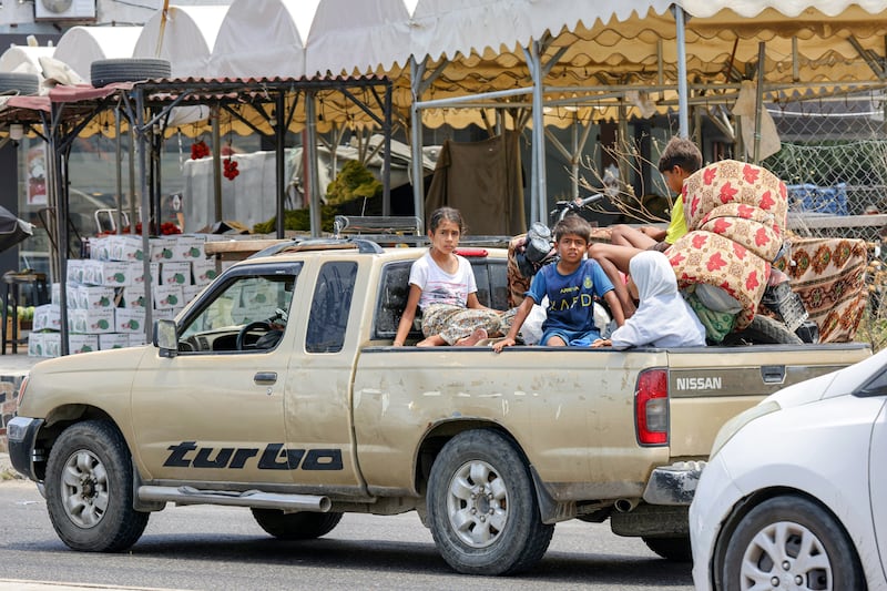 Children sit in the bed of a pickup truck as people fleeing from Tyre in southern Lebanon after Israel's evacuation warning. Photograph: Mahmoud Zayyat/AFP/Getty Images