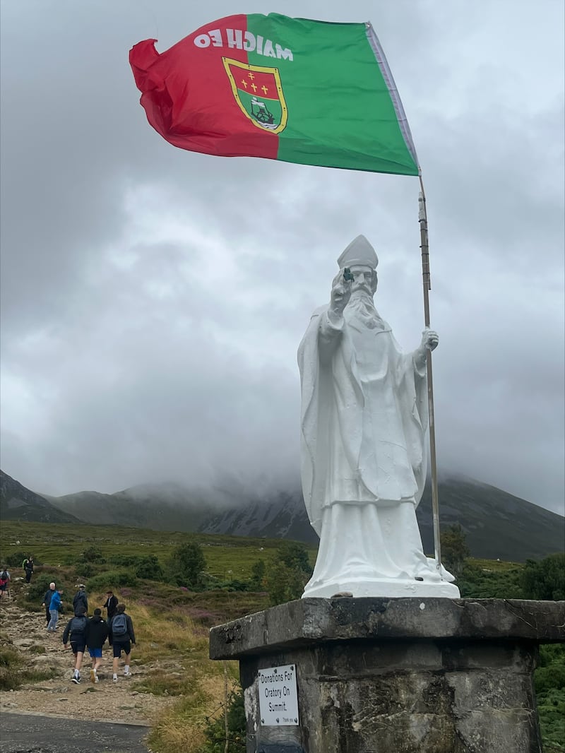 The statue of St Patrick on Croagh Patrick flies a Mayo GAA flag on Sunday as the county's senior football team achieved a historic victory over Kerry at Croke Park. Photograph: Michael McLaughlin