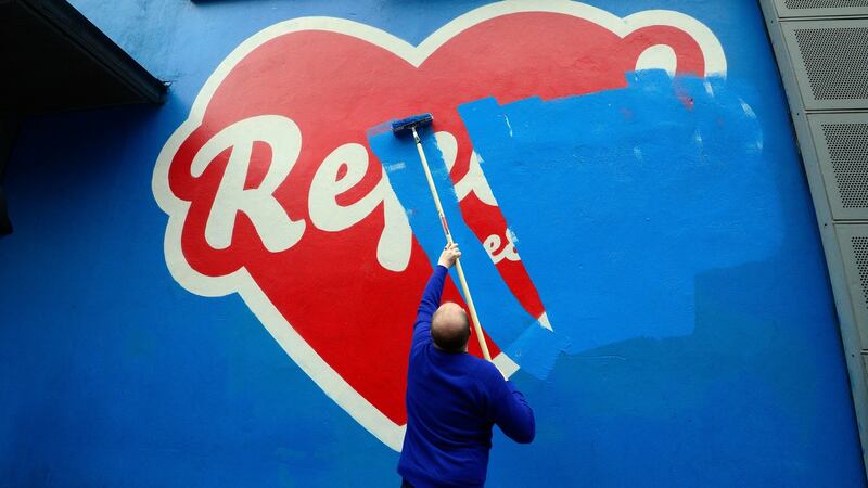 Cian O’Brien, artistic director of the Project Theatre, painting over the Repeal art work by artist Maser. Photograph: Cyril Byrne / The Irish Times
