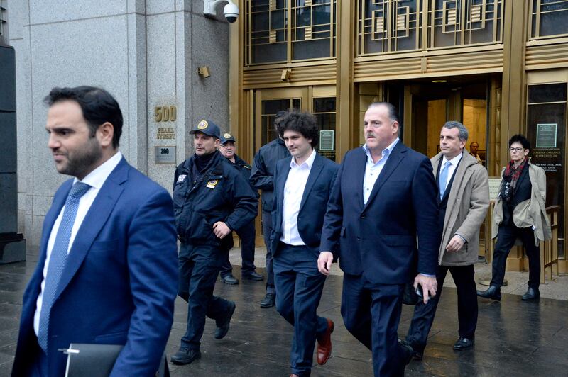 Sam Bankman-Fried, centre, founder of the crypto firm FTX, leaves Federal District court in Manhattan, on a previous court date. Photograph: Jefferson Siegel/The New York Times
                      